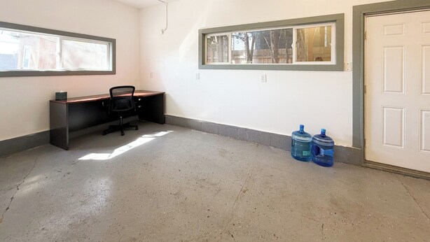A room with a desk, two windows, and two water dispensers. - Spacious 4 Bedroom Extended Stay Home | Pet Friendly (Newberg)