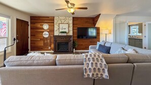 A living room with a fireplace, a television, and a sofa. - Spacious 4 Bedroom Extended Stay Home | Pet Friendly (Newberg)