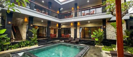 A multi-level outdoor pool area with seating and a staircase.
