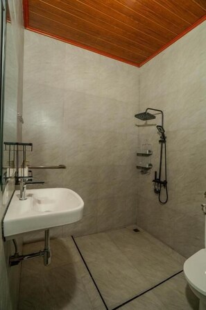 A bathroom with a shower, a sink, and a toilet.