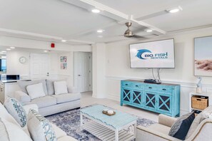 Ein modernes Wohnzimmer mit einer Couch, einem Couchtisch und einem an der Wand befestigten Fernseher.