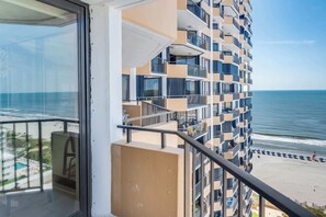 Ein Hochhaus mit mehreren Balkonen mit Blick auf einen Strand.