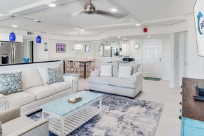 A spacious living room with a sofa, a coffee table, and a dining area with chairs. - Oceanfront Condo, Amazing View, Large 2 Bedroom (Myrtle Beach)