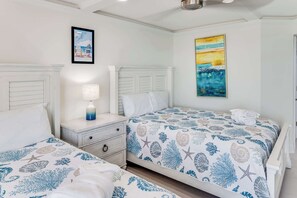 A hotel room with two beds, a nightstand, a lamp, and artwork on the walls. - Oceanfront Condo, Amazing View, Large 2 Bedroom (Myrtle Beach)