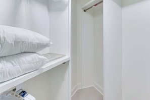 A white room with a shelf holding pillows and a framed picture. - Oceanfront Condo, Amazing View, Large 2 Bedroom (Myrtle Beach)