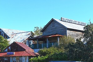 A rustic building with a sign reading 'HOUSE OF BLUES' and a smaller structure labeled 'GEAR SHOP' in the foreground. - Oceanfront Condo, Amazing View, Large 2 Bedroom (Myrtle Beach)
