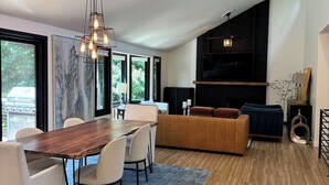 Ein modernes Wohnzimmer mit einem Holzespeisetisch, weißen Sofas und einem großen Fenster.