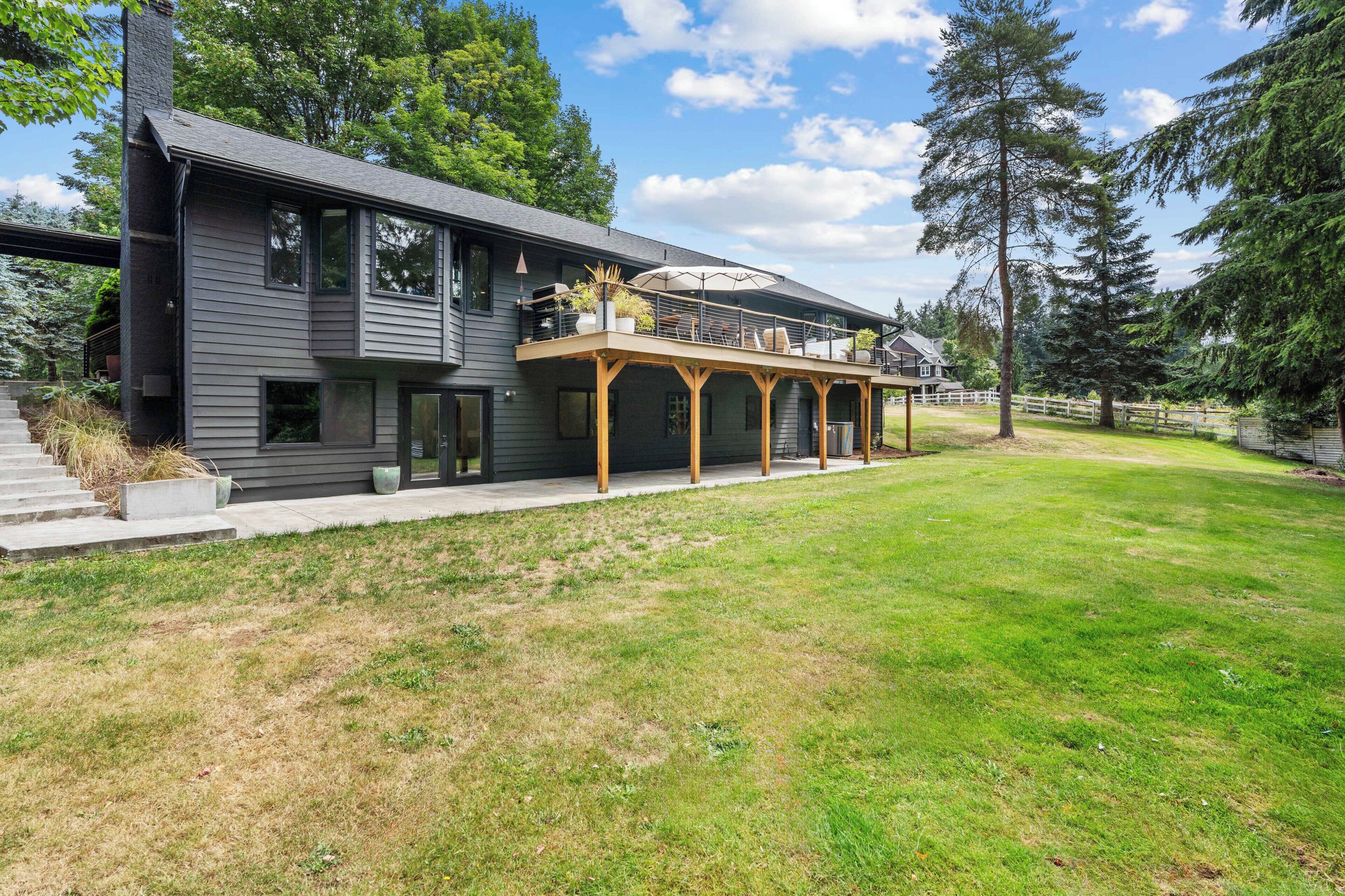 Een modern huis met twee verdiepingen en een overdekte patio.