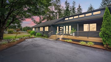 A modern two-story building with a covered porch and a driveway.