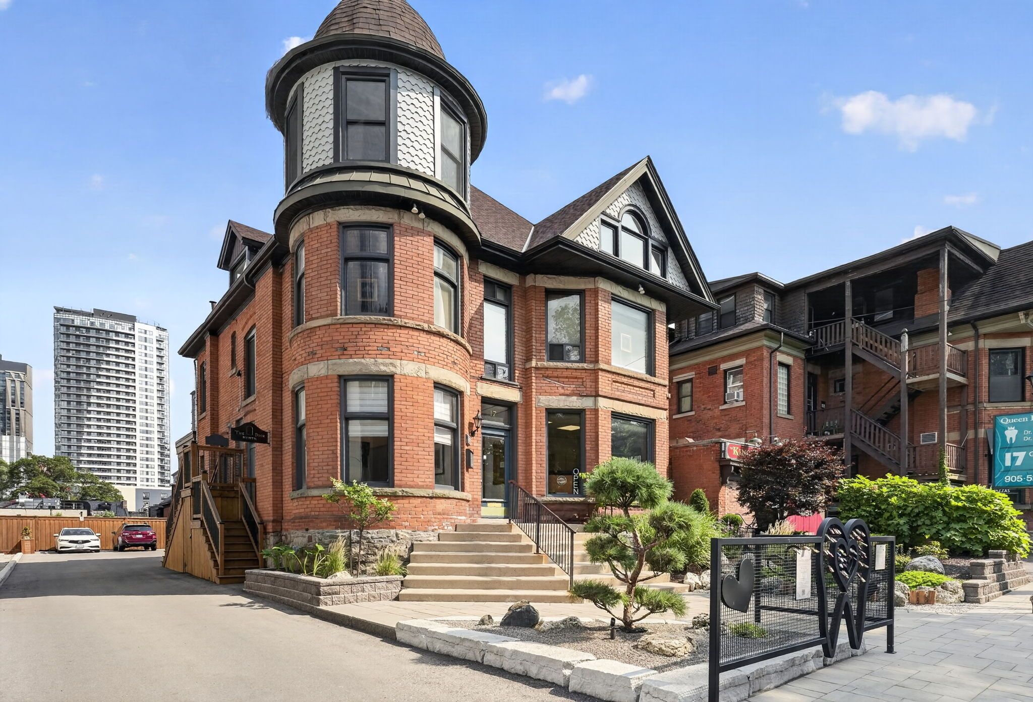 A Victorian-style building with a turret, brick facade, and multiple windows.