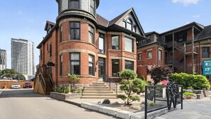 A Victorian-style building with a turret, brick facade, and multiple windows.