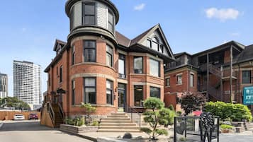 A Victorian-style building with a turret, brick facade, and multiple windows.