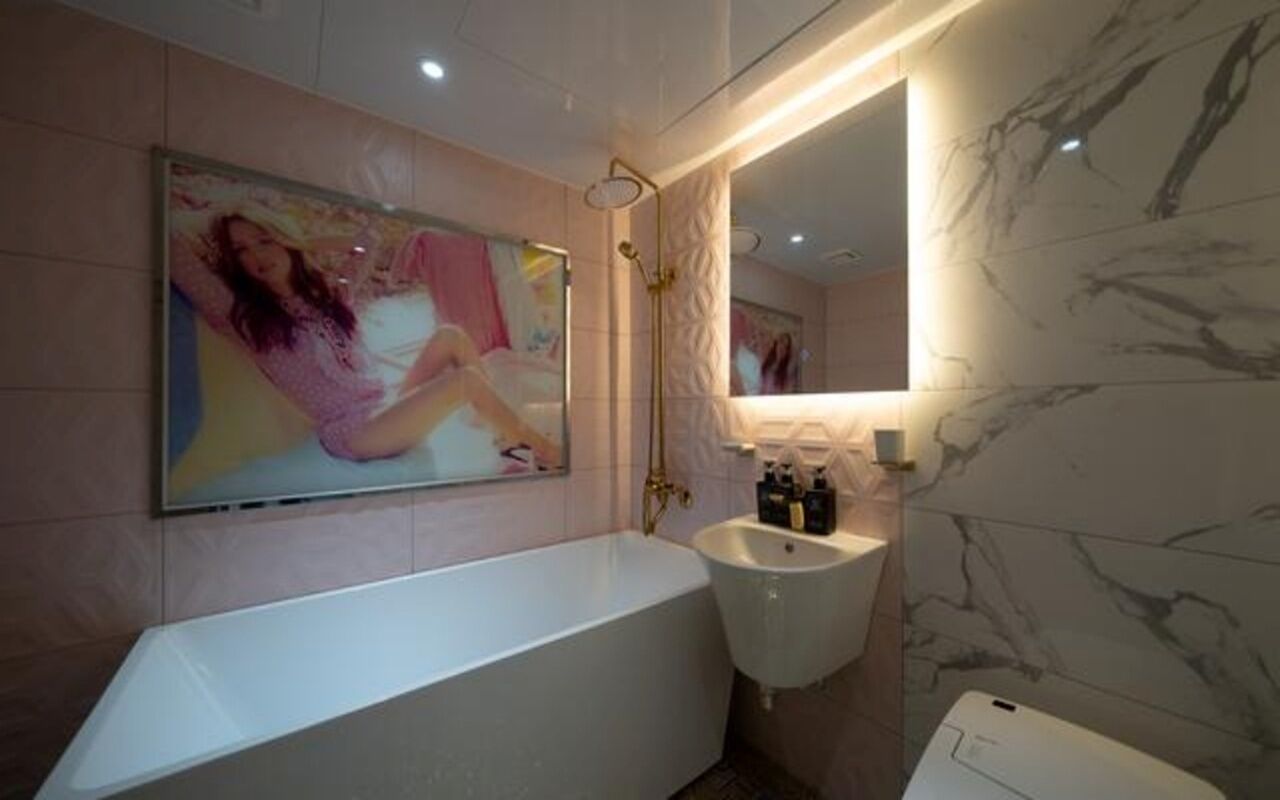 Ein modernes Badezimmer mit freistehender Badewanne, Waschtisch und großem Spiegel.