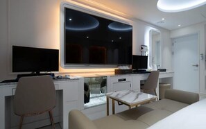 A modern hotel room with a large flat-screen TV, a desk with a computer, a comfortable sofa, and a small table. - Incheon Myeongpum Hotel (Incheon)
