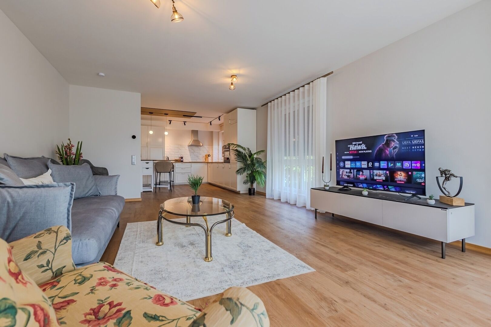 A modern living room with a sofa, a coffee table, and a TV.