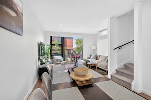 Ein modernes Wohnzimmer mit einer Couch, einem Couchtisch und einer Treppe.