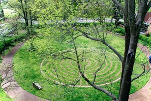 Ein kreisrunder Garten mit einem gewundenen Pfad und einer Bank.