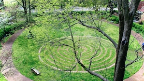 A circular garden with a winding path, a bench, and a tree in the foreground. - Converted Suite in the Historic Scarritt Bennett!! (Nashville)