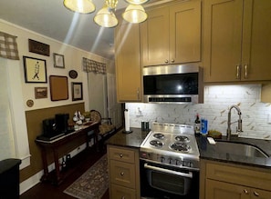 A kitchen with wooden cabinets, a stainless steel stove, and a tiled backsplash.