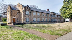 A stone building with a central entrance, multiple windows, and a paved pathway leading to it. - Converted Suite! AMAZING LOCATION! (Nashville)