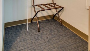 A corner of a hotel room with a metal rack holding towels, a metal chair, and a thermostat on the wall. - AWESOME Location!! Budget Friendly Historic Suite! (Nashville)