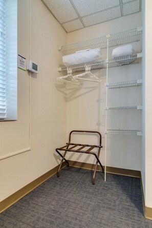 A corner of a hotel room with a metal drying rack, a white towel rack, and a thermostat on the wall. - Converted Dorm in Historic Scarritt Bennett!! (Nashville)