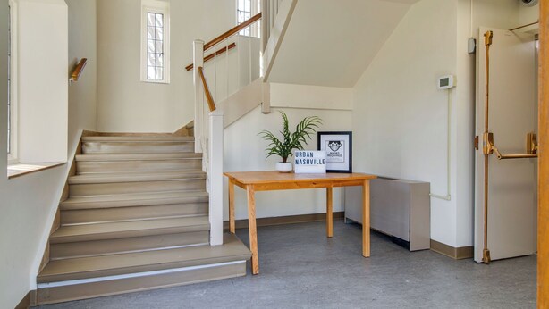 Eine Treppe mit Holzstufen und einer Handlauf, die zu einer oberen Etage führt.