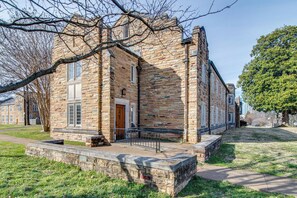 A stone building with a wooden door and windows, surrounded by grass and trees. - Perfect Suite for Travel on a Budget! Music Row!! (Nashville)