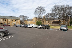 A parking lot with multiple cars and a building with a stone facade in the background. - Cozy Suite in a Historic Building! GREAT location (Nashville)