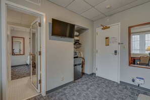 A hotel corridor with a microwave, a refrigerator, and a flat-screen TV mounted on the wall. - Cozy Suite in a Historic Building! GREAT location (Nashville)