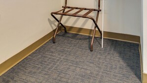 A corner of a room with a metal drying rack and a white wall. - Unique Historic Dorm Suite in Prime Location (Nashville)