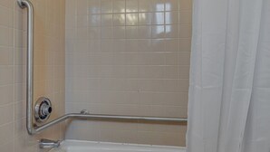 A bathroom with a bathtub, a shower with a grab bar, and a white towel. - Private Suite in a Great Location - Music Row! (Nashville)