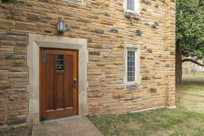 Un edificio de piedra con una puerta de madera y una ventana pequeña.