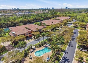 A residential area with multiple houses, a swimming pool, and a road. - Resort Like Living!  Walk to Coconut Point in Beautiful Rapallo in Estero! (Estero)