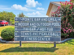 A directional sign with arrows pointing to various amenities including a bar, pool, and fitness center. - The Luxe @ Pointe Royale Resort (Branson)