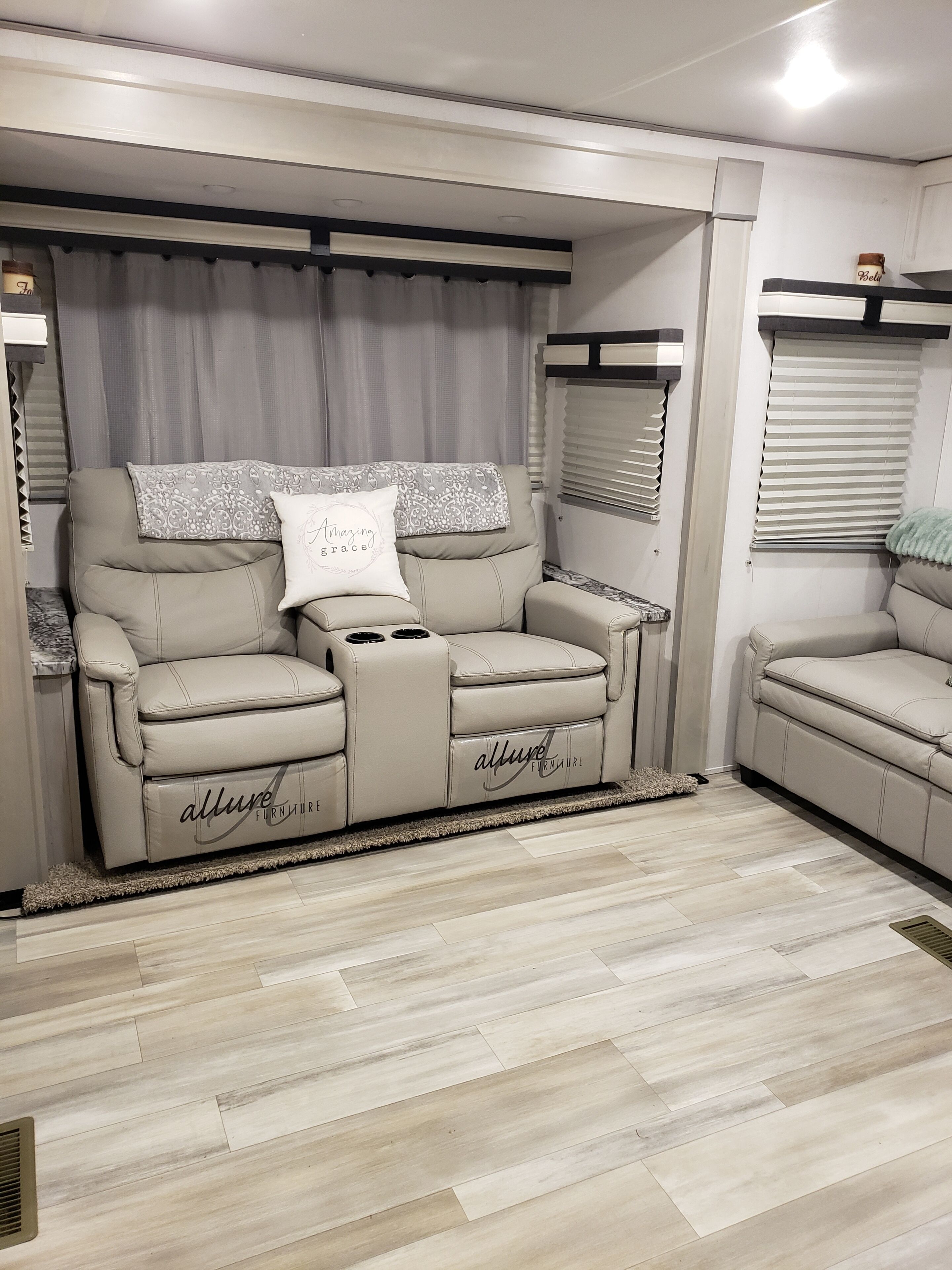 A modern living room with a beige sofa set, a small table, and a decorative pillow.