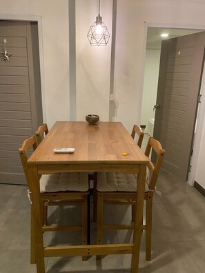 Ein Holztisch mit Fernbedienung und Schlüsselanhänger, umgeben von gepolsterten Stühlen.