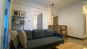 Ein Wohnzimmer mit einer Couch, einem Couchtisch und einem Essbereich mit Tisch und Stühlen.