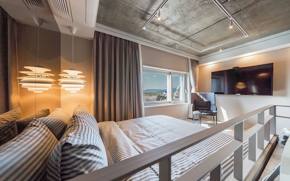 A modern hotel room with a bed, a TV, a window with a view, and a balcony. - Busan Sasang Mr. Brick Hotel (Busan)