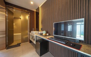 A modern bathroom with a shower, a sink, and a toilet. There is a computer desk with a monitor, keyboard, and mouse. - Busan Sasang Mr. Brick Hotel (Busan)