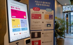 Un écran numérique et une affiche d’information dans le hall d’un hôtel.