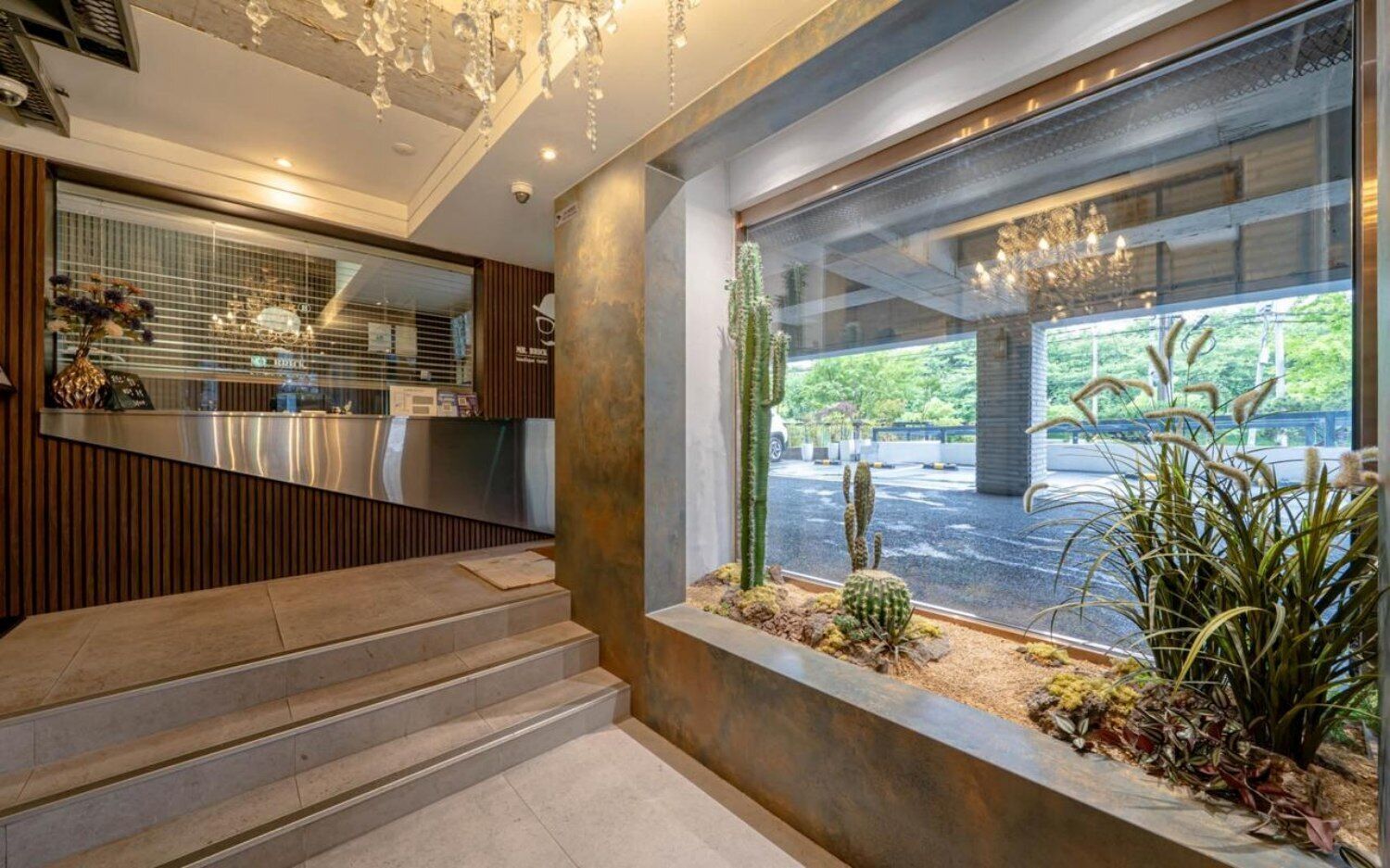 A reception area with a counter, a staircase, and a window with a view of the outside.