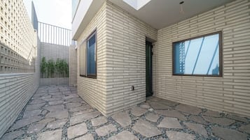 A modern building with a brick facade, large windows, and a stone-paved courtyard.
