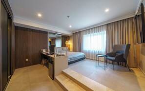 A modern hotel room with a bed, a desk, a chair, and a small table. - Busan Sasang Mr. Brick Hotel (Busan)