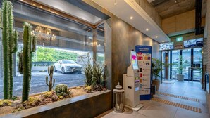 A hotel lobby with a reception desk, a self-service kiosk, and a view of the street outside. - Busan Sasang Mr. Brick Hotel (Busan)