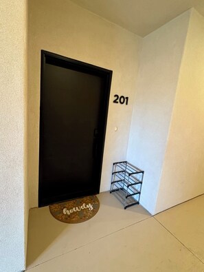 A door with the number 201 on the wall, a metal rack, and a welcome mat with 'welcome' written on it. - Splash Zone | A Family Favorite near Zion (Hurricane)