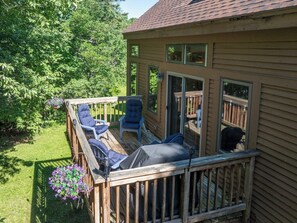 Eine Terrasse mit Gartenmöbeln, einem überdachten Sitzbereich und Blick ins Grüne.