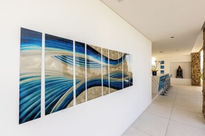 A hallway with a large abstract painting, a stone wall, and a bar area with chairs. - Blue View Luxe by Sublime Samui Villas (Koh Samui)