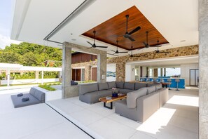 A modern outdoor living area with a sofa, a coffee table, and a dining table. - Blue View Luxe by Sublime Samui Villas (Koh Samui)