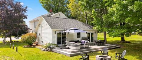A single-story house with a patio area, outdoor furniture, and a small garden.